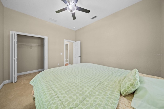 bedroom with light colored carpet, ceiling fan, and a closet