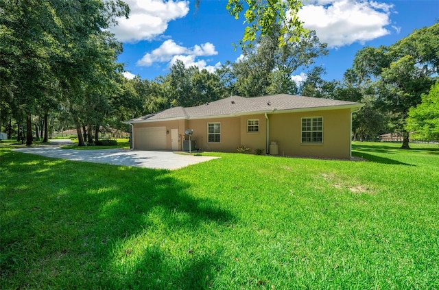 rear view of property with a yard and a garage