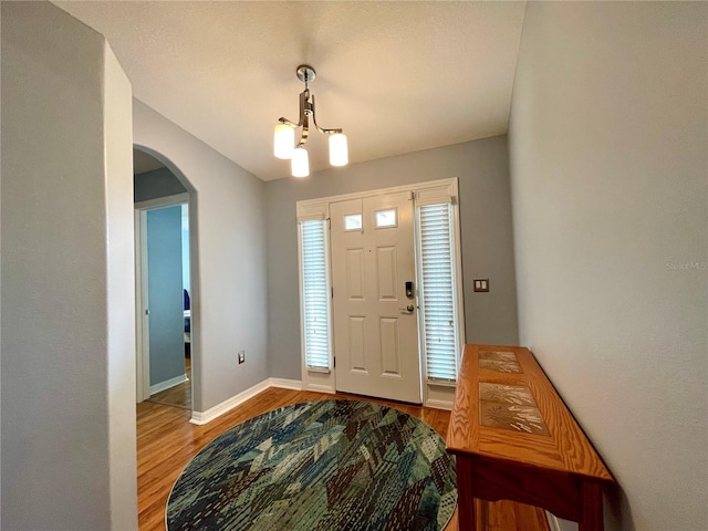 entrance foyer with a notable chandelier and hardwood / wood-style flooring