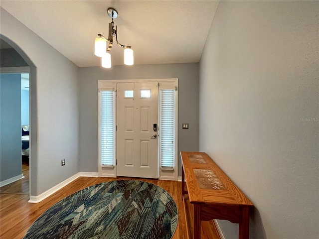 entrance foyer with hardwood / wood-style floors and a chandelier