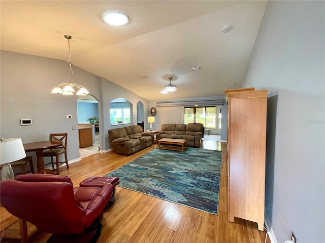 living room featuring an inviting chandelier, light wood-type flooring, and lofted ceiling