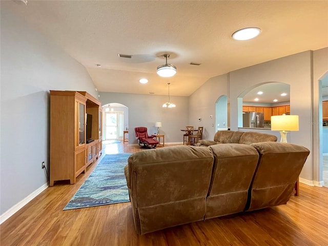 living room featuring light hardwood / wood-style flooring and vaulted ceiling