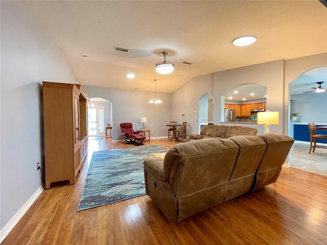 living room with vaulted ceiling, ceiling fan, and light hardwood / wood-style floors