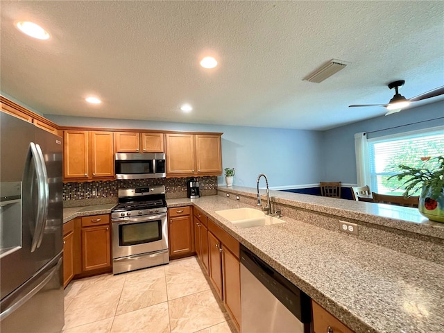 kitchen featuring tasteful backsplash, light tile patterned floors, appliances with stainless steel finishes, ceiling fan, and sink