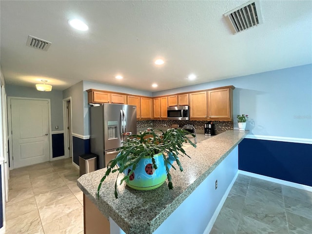 kitchen featuring appliances with stainless steel finishes, kitchen peninsula, light tile patterned floors, and tasteful backsplash