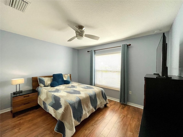 bedroom featuring ceiling fan, a textured ceiling, and hardwood / wood-style floors