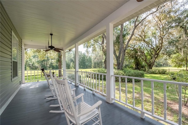 wooden deck featuring a yard and ceiling fan