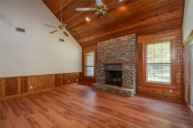 unfurnished living room with visible vents, wainscoting, a fireplace, wooden ceiling, and wood finished floors