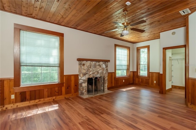 unfurnished living room with a wainscoted wall, visible vents, and wooden ceiling