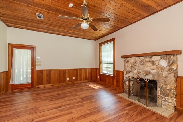 unfurnished living room with ceiling fan, wooden ceiling, a stone fireplace, and hardwood / wood-style flooring