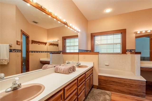 full bath with a sink, visible vents, and wallpapered walls