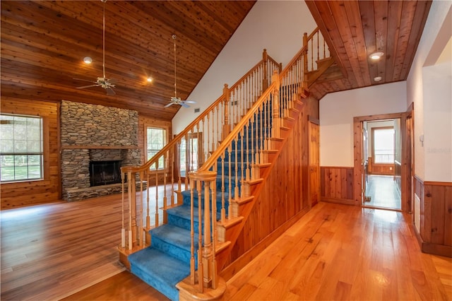 stairway featuring ceiling fan, a healthy amount of sunlight, hardwood / wood-style floors, and wood ceiling