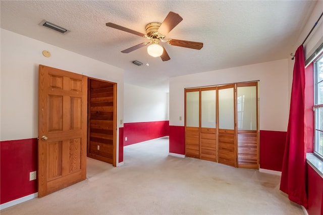 bedroom featuring multiple windows, ceiling fan, and light colored carpet