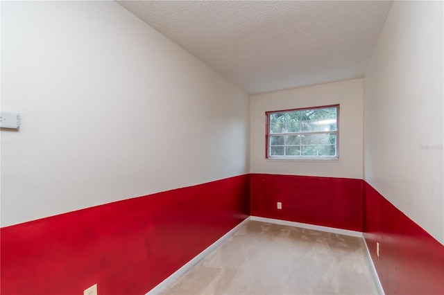 unfurnished room featuring carpet and a textured ceiling