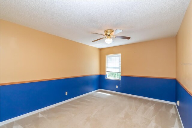 empty room with ceiling fan, a textured ceiling, and carpet floors