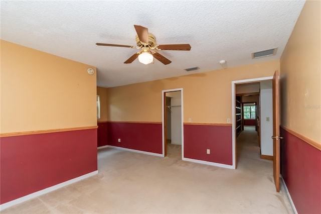 carpeted empty room featuring ceiling fan and a textured ceiling