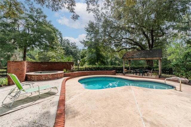 view of pool with an in ground hot tub and a patio