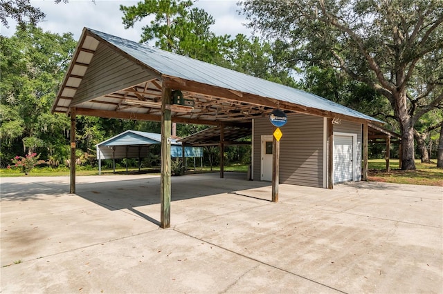 view of patio featuring a carport, a garage, and an outbuilding