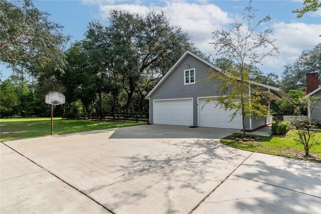 view of side of property featuring a garage and a yard