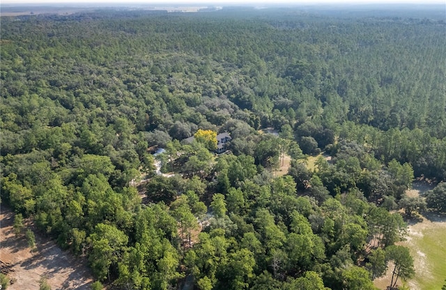 bird's eye view with a wooded view