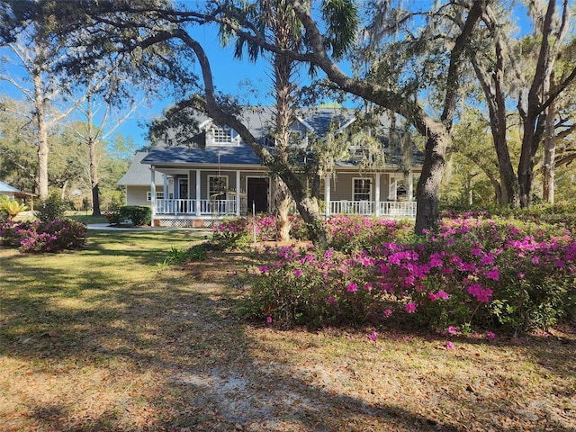 new england style home featuring covered porch and a front lawn