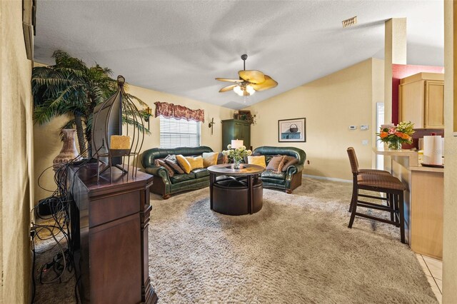 living room with ceiling fan, a textured ceiling, lofted ceiling, and light colored carpet