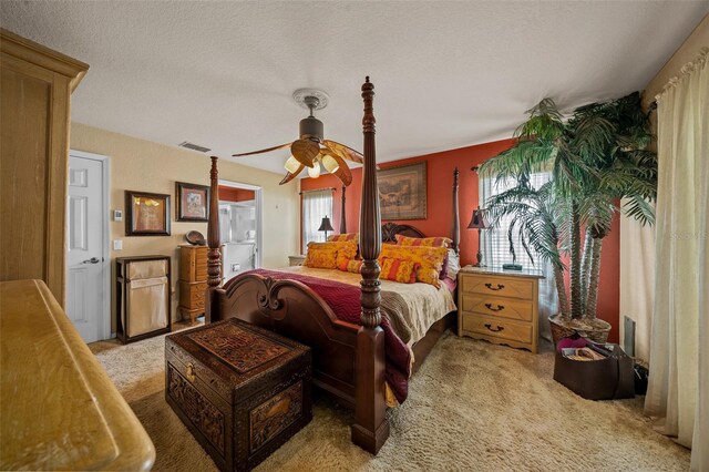 bedroom with a textured ceiling, carpet flooring, ceiling fan, and multiple windows