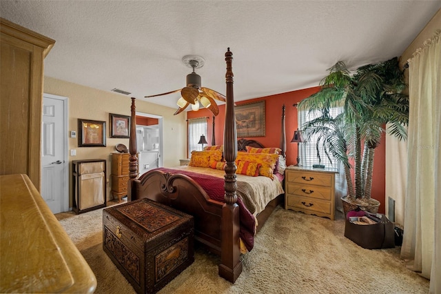 bedroom featuring a ceiling fan, visible vents, a textured ceiling, and light colored carpet