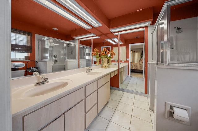 bathroom with tile patterned flooring, double sink vanity, and a shower with shower door