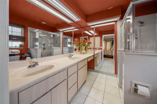 ensuite bathroom with double vanity, a sink, ensuite bath, and tile patterned floors