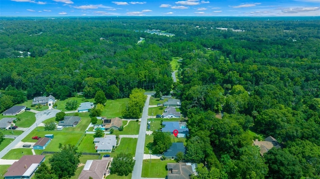 drone / aerial view featuring a residential view and a wooded view