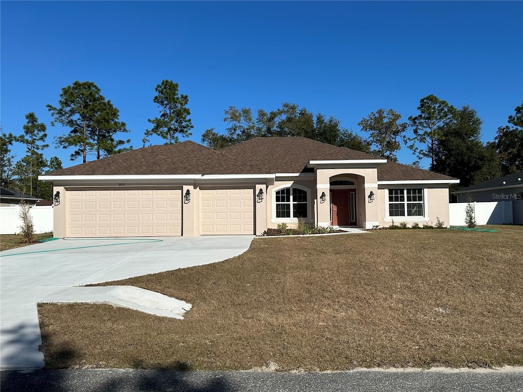 single story home featuring a garage and a front yard