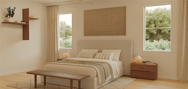 bedroom with light hardwood / wood-style flooring, ceiling fan, and multiple windows