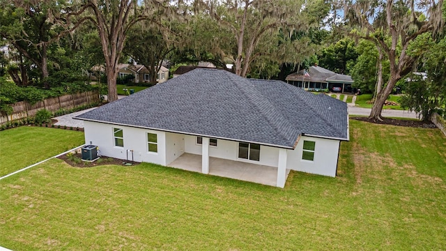 rear view of house with central air condition unit, a patio area, and a lawn