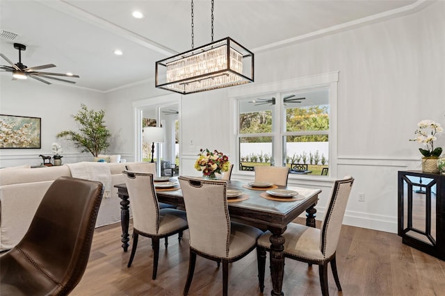 dining room featuring crown molding, ceiling fan with notable chandelier, and hardwood / wood-style flooring