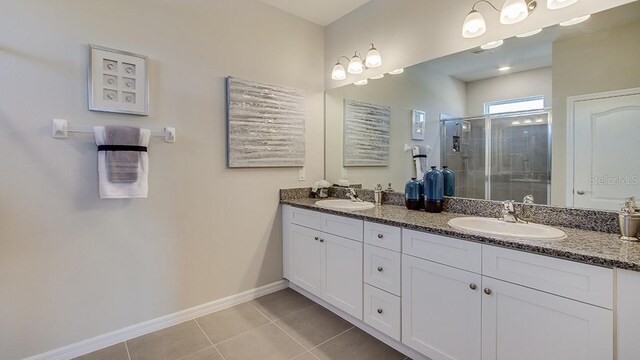 bathroom featuring double vanity, tile patterned flooring, and a shower with shower door