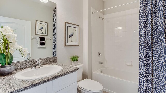 full bathroom featuring tiled shower / bath, vanity, and toilet