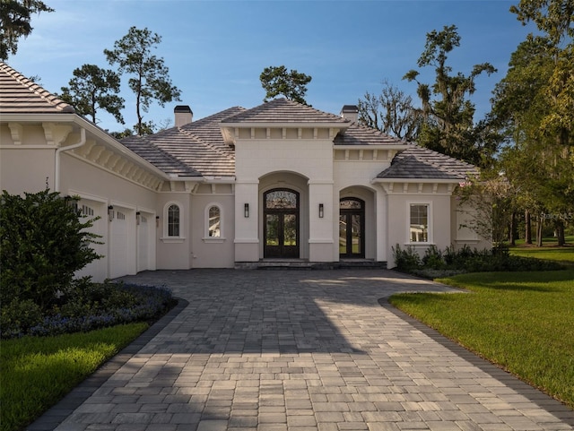 mediterranean / spanish-style house featuring a garage and a front yard