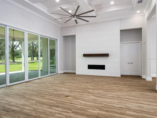 unfurnished living room featuring a large fireplace, coffered ceiling, and wood finished floors