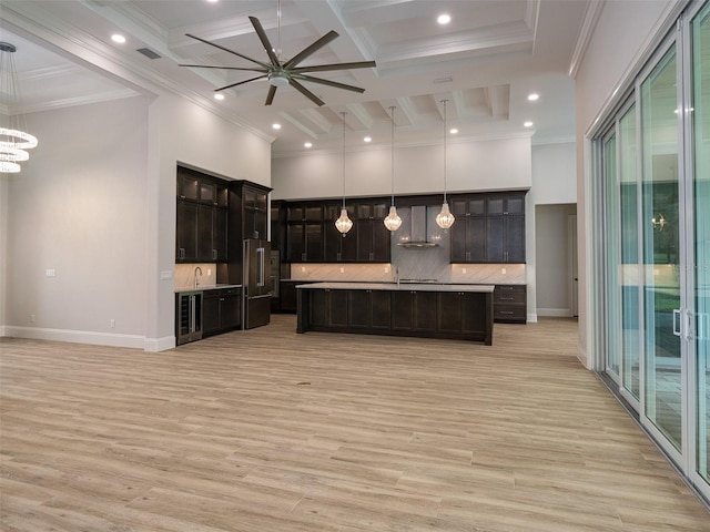 kitchen featuring a high ceiling, light countertops, open floor plan, wine cooler, and tasteful backsplash
