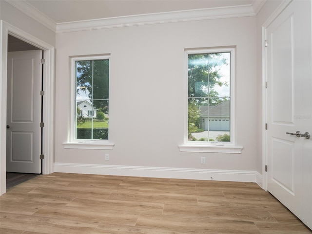 unfurnished room featuring plenty of natural light, ornamental molding, and light wood finished floors
