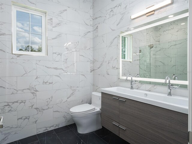 bathroom with tile patterned floors, toilet, vanity, and tile walls