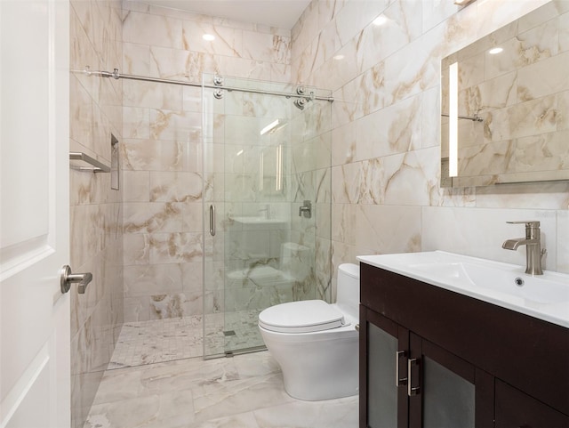 full bath with vanity, a shower stall, tile walls, toilet, and marble finish floor