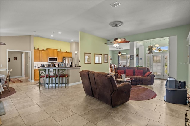 living room featuring light tile patterned floors, ceiling fan with notable chandelier, and lofted ceiling