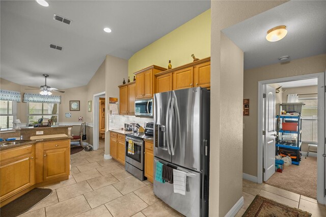 kitchen with tasteful backsplash, light tile patterned floors, stainless steel appliances, and ceiling fan