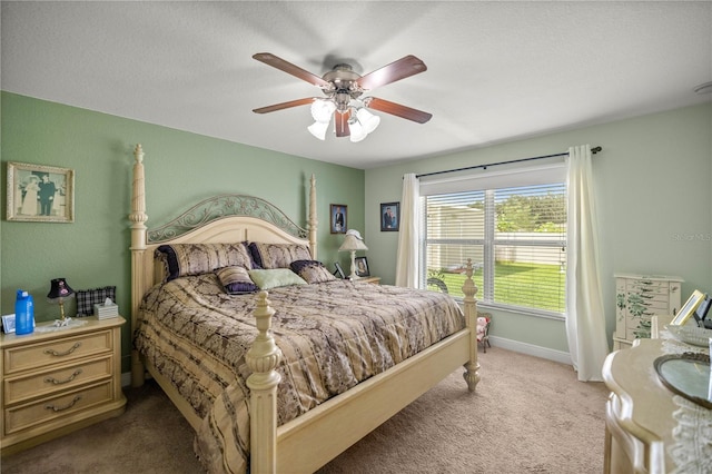 carpeted bedroom featuring ceiling fan and a textured ceiling