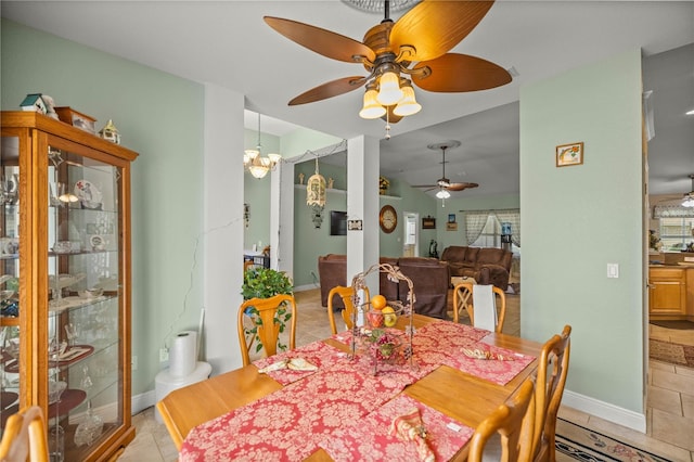 dining space featuring light tile patterned floors and ceiling fan with notable chandelier