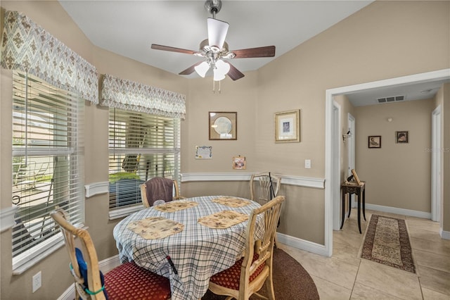 dining space with ceiling fan, light tile patterned flooring, and lofted ceiling