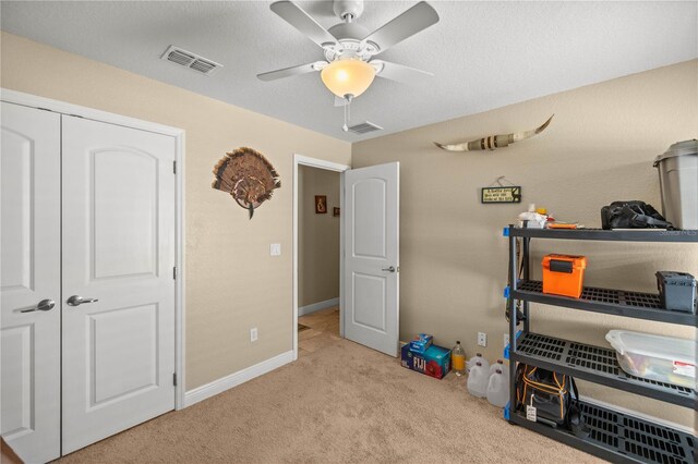 interior space featuring ceiling fan and light carpet