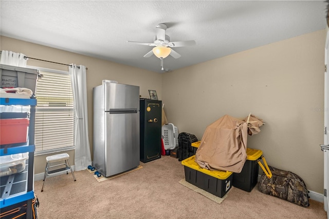 interior space with light carpet, ceiling fan, and a textured ceiling